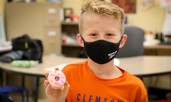 Boy holds up food model made of clay